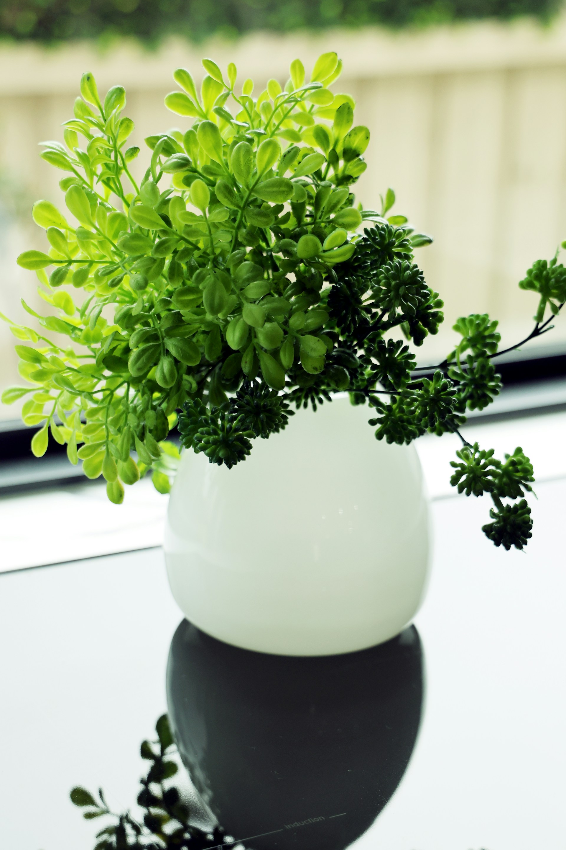 Artificial plant arrangement in a white vase for home decor