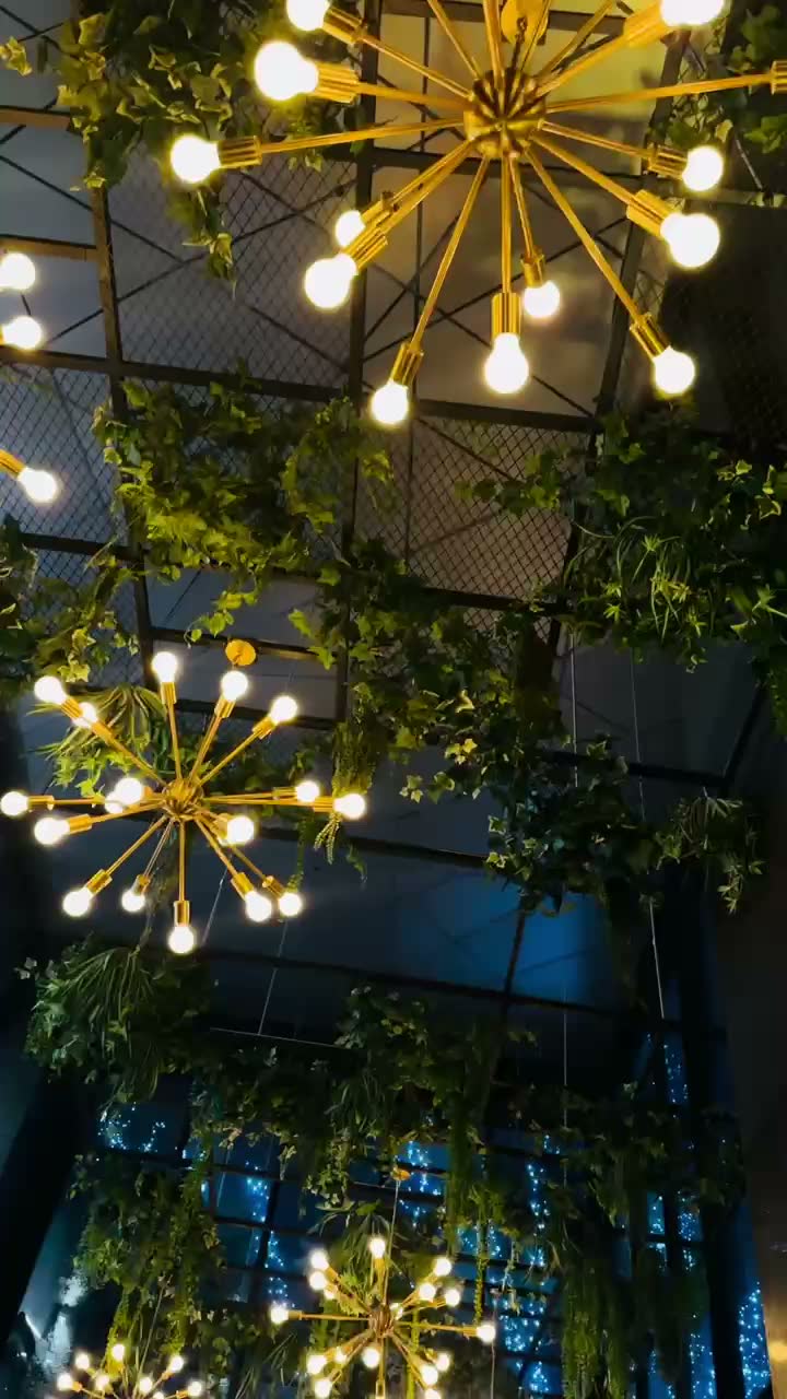 Ceiling greenery and chandelier installation at a lounge